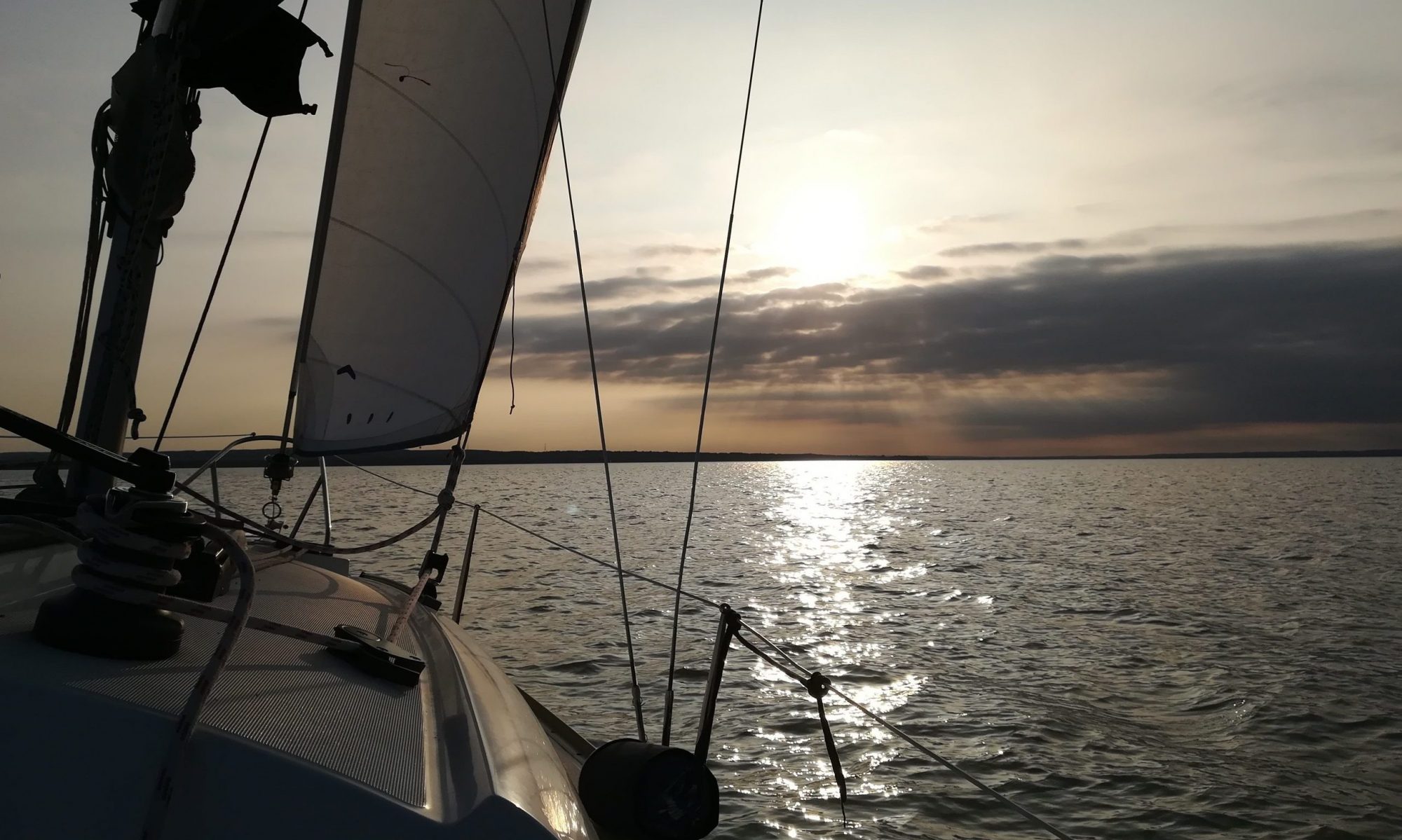Vitorlázás a Balatonon naplementében